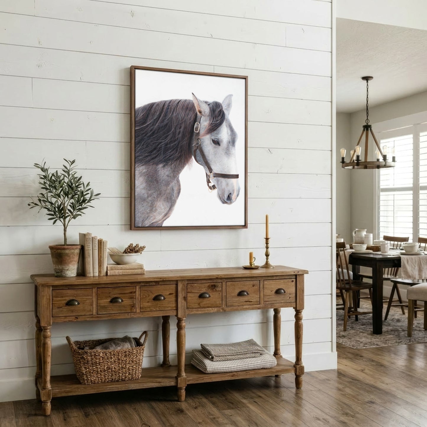 A framed black and white horse portrait hangs on a white shiplap wall above a rustic wooden console table in a bright, modern farmhouse-style dining room.